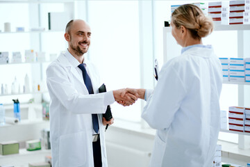 pharmacy staff greeting each other with a handshake.