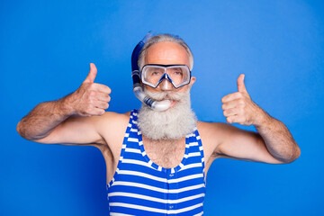 Photo of grey haired elderly man make thumbs up wear mask diver wear swimsuit isolated on blue...