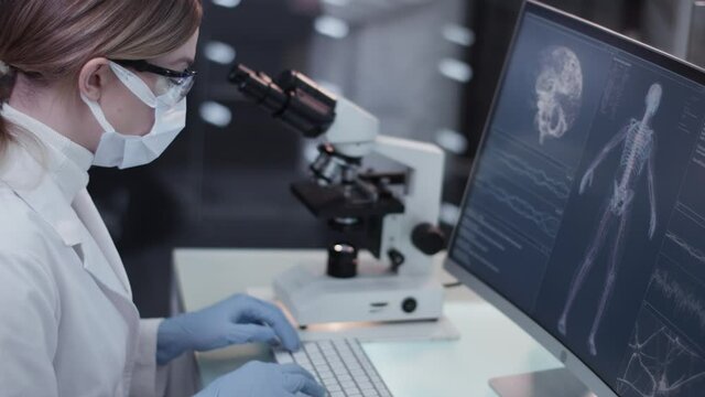 Female doctor working in laboratory. Studying human skeleton and DNA samples with coworker