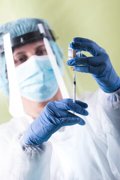 Vaccination, doctor in protective clothes with syringe and ampule, vertical version