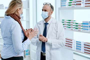 pharmacist showing a mature woman a package of pills.
