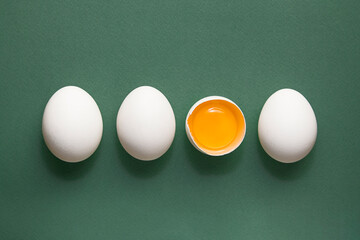 Four White eggs, yolk on green pastel background. Minimal concept.