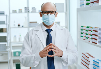 pharmacist consultant standing near the shelves with medicines .
