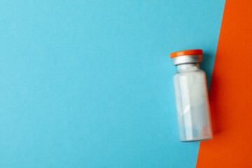 Vial with powder vaccine on two tone background