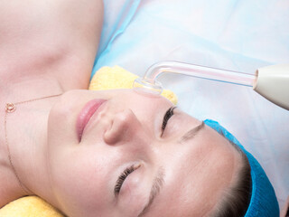 High frequency facial treatment promoting the blood circulation of the skin and disinfecting...
