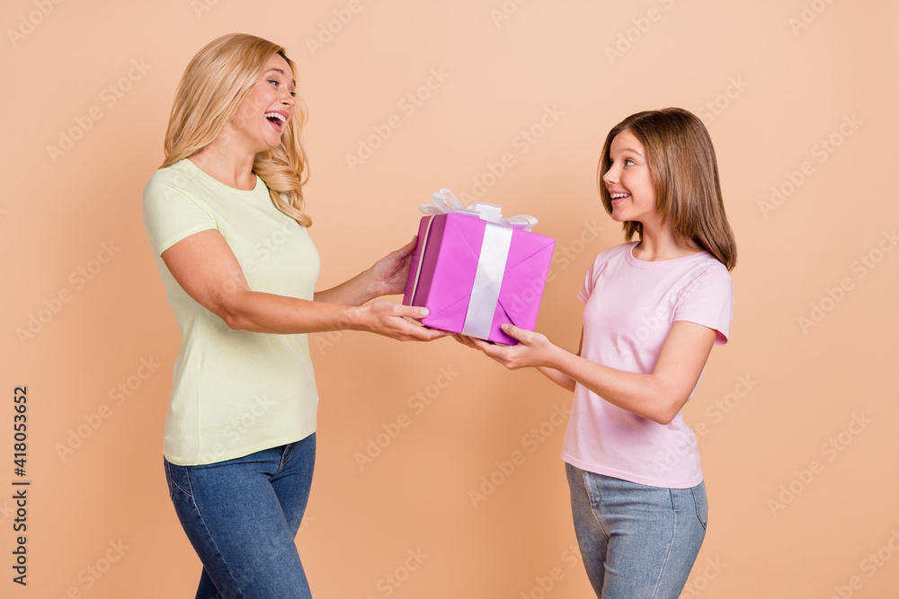 Poster photo of happy mother and daughter receive gift wear jeans smile isolated on pastel beige color back