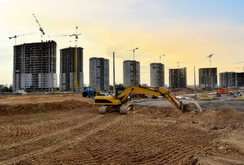 Excavator doing earthworks during the construction of a road in a new residential area in the city....