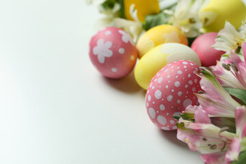 Color Easter eggs and alstroemeria flowers on white background