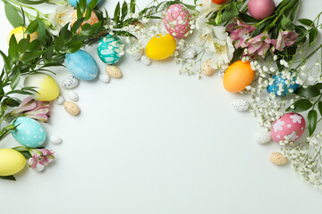 Fototapeta na wymiar Easter eggs and beautiful flowers on white background, space for text