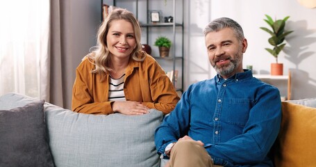 Portrait of joyful Caucasian middle-aged happy family couple man and woman smiling and looking at camera in good mood, positive emotions, family love relationships