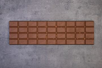 sweet delicious chocolate lies on dark gray stone background