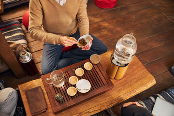 Young man performing tea ceremony in cozy cafe