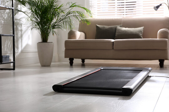 Modern walking treadmill in living room. Home gym equipment