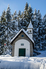 chiesetta in mezzo agli alberi con la neve