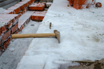 Hammer and bricks. Construction of walls.