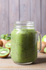 Delicious kiwi smoothie and fresh fruits on wooden table