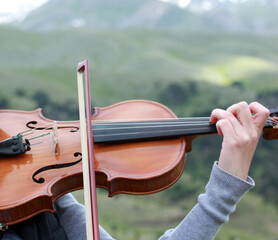 Female violinist playing the violin in nature