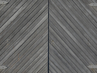 Fototapeta premium Texture of gray surface from boards. Large wooden gate. Light falls from the evening sun.