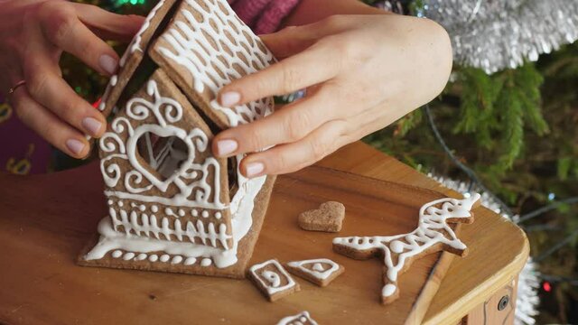 woman girl decorating christmas gingerbread making a house royal icing