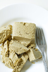 tasty eastern sunflower halwa on white dish with fork, cheat meal