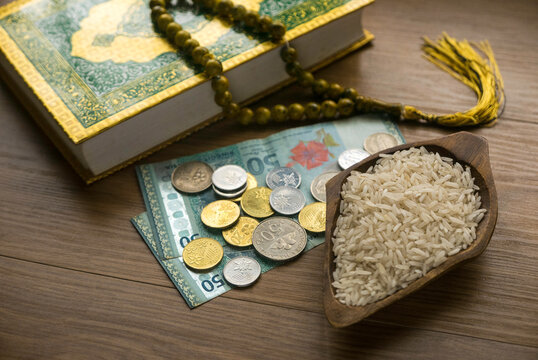 Concept of zakat in Islam religion. Selective focus of money, rice, Koran and prayer beads on wooden background. 