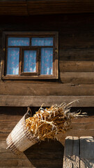 wooden village house window and wheat ears in basket