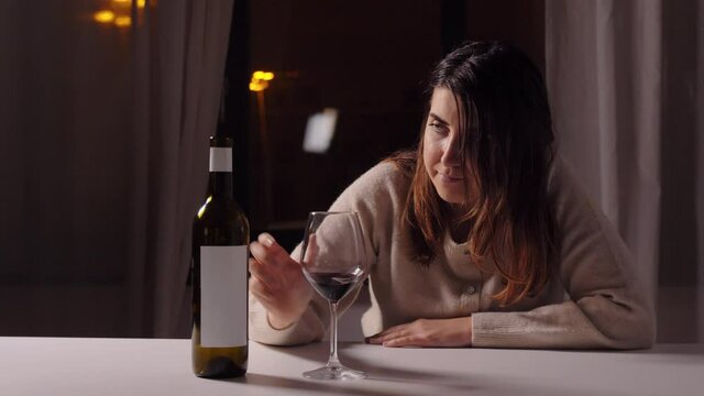 alcoholism, alcohol addiction and people concept - drunk woman or female alcoholic drinking red wine at home at night