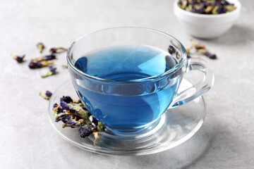Obraz na płótnie Canvas Glass cup of organic blue Anchan on light table. Herbal tea