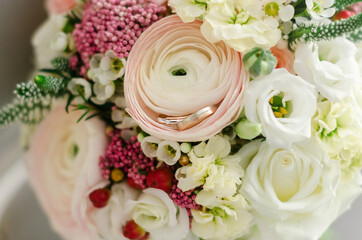 Wedding rings on the background of the bride's bouquet. Close-up. Soft focus.