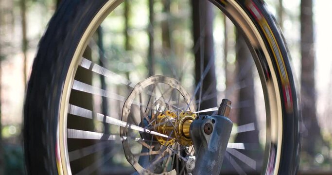 Upside down mountain bike front wheel and tire wheel spinning freely in the forest close up shot no people shallow depth of field