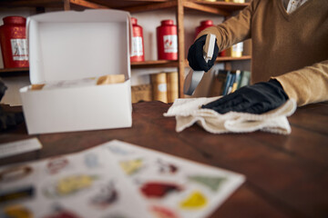 Male worker in sterile gloves cleaning counter in cafe