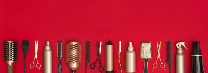 Modern hairdresser tools arranged in a line on red background