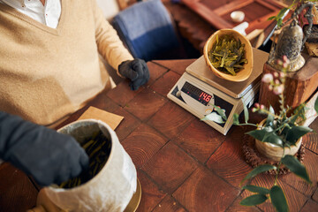 Male worker weighing tea leaves in tea shop