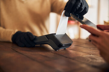 Male worker using terminal for contactless payment