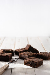 Homemade pieces of brownies on wooden table. Copy space