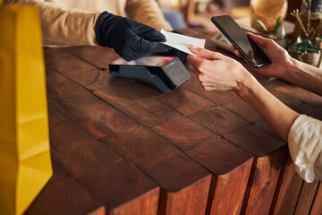 Female customer using smartphone to pay for purchases