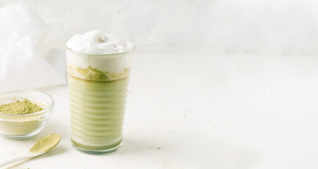 Matcha tea with milk on a light gray background. Copy space. Banner