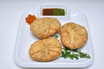 Kachori with dry garlic chutney garnished with coriander leaves