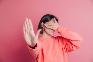 Woman wearing casual sweater on background covering eyes with hands and doing stop gesture with sad and fear expression