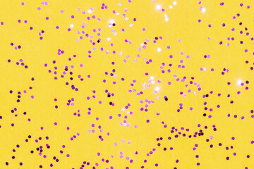 bright fuchsia pink shiny glitter on a yellow background