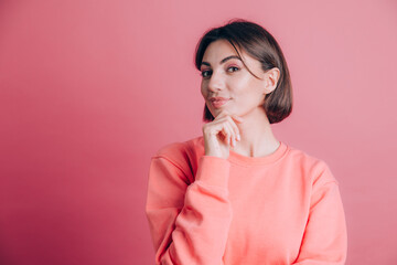 Woman wearing casual sweater on background hand on chin thinking about question, pensive expression. Smiling with thoughtful face