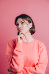 Woman wearing casual sweater on background hand on chin thinking about question, pensive expression. Smiling with thoughtful face