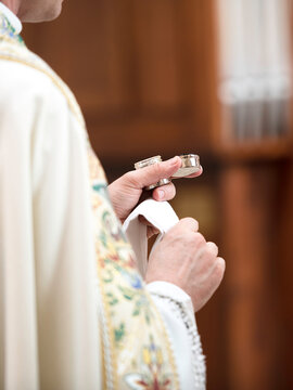 Close-up of a catholic priest saying prayers and giving communion