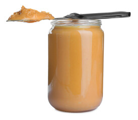 Glass jar and knife with tasty peanut butter on white background