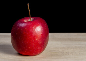 Pomme rouge sur une planche de bois avec fond noir