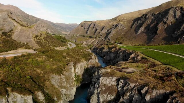 Beautiful view of rocky river canyon, rock formations and vineyard, New Zealand - aerial