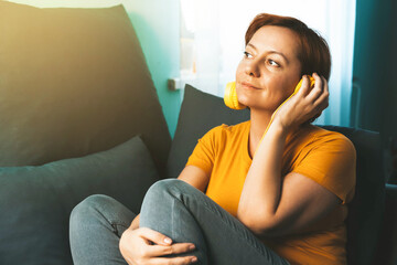 Obraz premium Beautiful woman sitting at home on the sofa wearing headphones