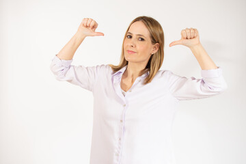 Smiling young woman in casual clothes posing isolated over white background. People sincere emotions lifestyle concept. Mock up copy space. Pointing thumbs on herself.