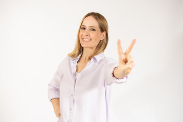 Blonde woman over isolated background smiling and showing victory sign