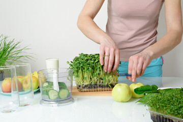 step-by-step recipe for making smoothies from micro-green apples cucumber and spinach. woman hands cut vegetables and put them in blender for whipping eco organic fresh food detox on light background